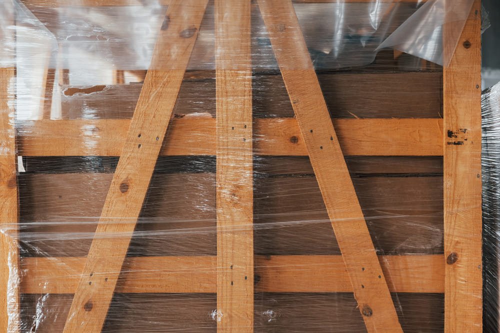 Securely packed wood furniture in a reinforced cardboard box with foam padding and corner protectors, ready for shipping.
