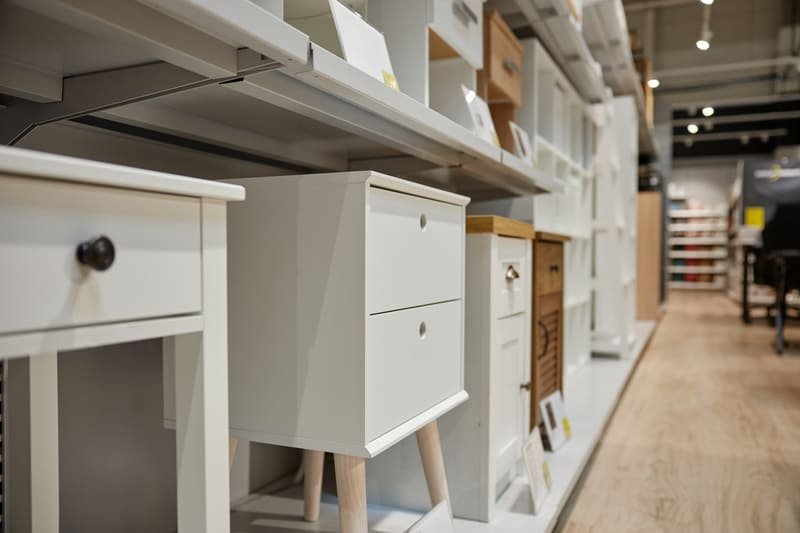 A well-organized wood furniture retail store displaying a variety of wooden tables, chairs, cabinets, and dressers in a stylish showroom setting.