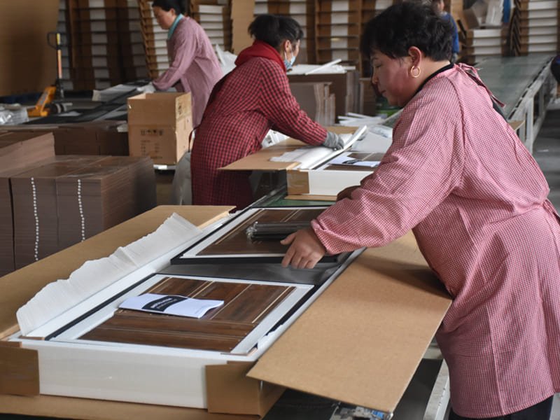 Skilled workers assembling wooden furniture in a well-organized assembly workshop, using tools to fit components together.