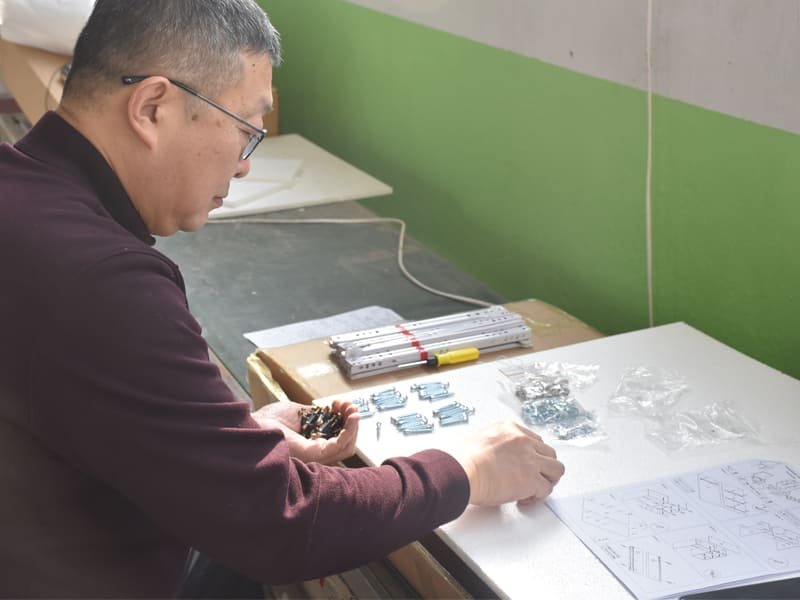Technicians in a quality control and inspection workshop carefully examining a wooden table for durability, finish consistency, and structural integrity.