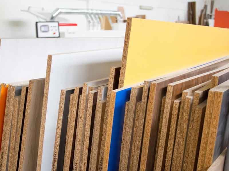 Quality control technician inspecting MDF board thickness and surface smoothness in factory