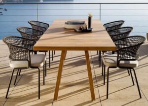Durable wicker patio set with weather-resistant cushions under a pergola, perfect for outdoor relaxation.