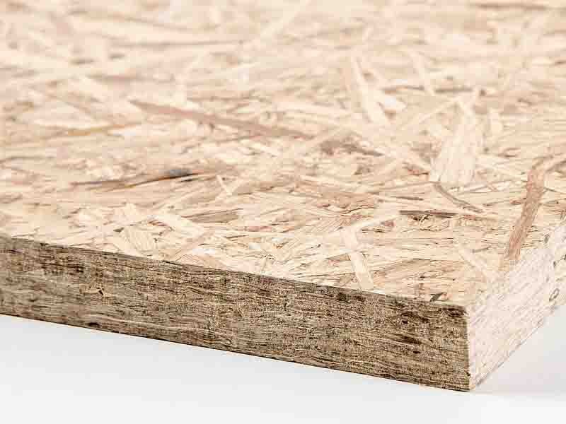Recycled wood chips pressed into gold-certified FSC chipboard sheets – carbon-negative building material for circular economy furniture