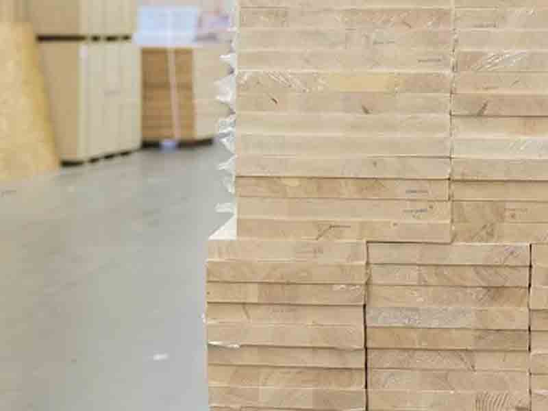 Person applying protective wax to chipboard table edge – demonstrating routine maintenance to extend particle board furniture lifespan