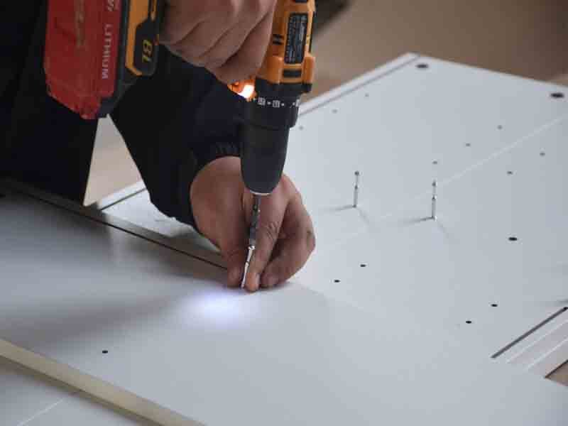 Step-by-step engineered wood bookcase installation with tools and hardware displayed
